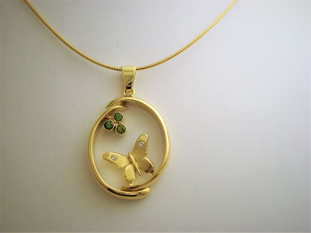 Herinneringshanger. 2 Delen van de trouwringen. Van de rest de vlinder gemaak. Gezet met 2 diamantjes en 3 tourmalijntjesGoudsmid Hans Rietman